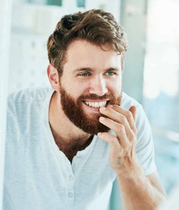 A man checking his teeth after dental crown